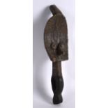 AN AFRICAN HARDWOOD AND BRASS FIGURE OF A MALE with a pointed nose. 9.75ins high.