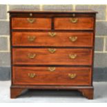 A GEORGE III MAHOGANY SATINWOOD BANDED CHEST fitted with a brushing slide, with two short and