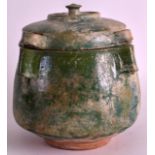 A 10TH TO 12TH CENTURY PERSIAN GREEN GLAZED POT AND COVER with four angular supports. 7.5ins high.