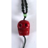 A CHINESE CARVED CORAL SKULL NECKLACE. 1.25ins long.