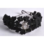 A VERY UNUSUAL IRISH CARVED BOG OAK WHITE METAL LADIES BRACELET.