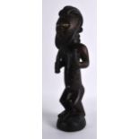 A CARVED AFRICAN HARDWOOD FIGURE OF A MALE modelled with genitals exposed, upon a circular base. 1Ft