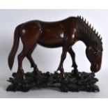 AN EARLY 20TH CENTURY CHINESE CARVED HARDWOOD FIGURE OF A HORSE Qing, unusually finely carved upon a