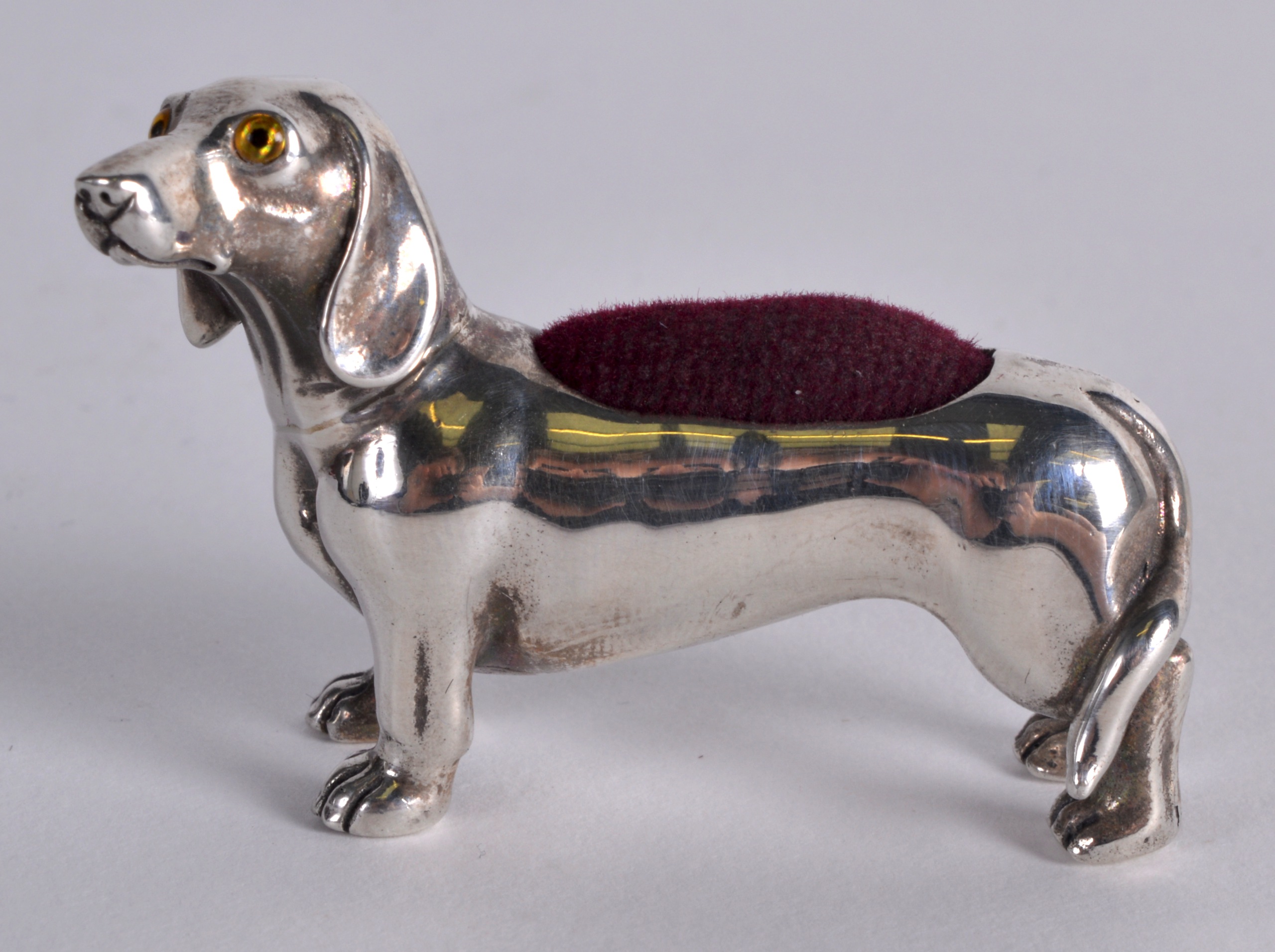 A SILVER 'DOG' PIN CUSHION.