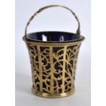 A SMALL EDWARDIAN SILVER GILT PIERCED BASKET with blue glass liner. London 1901. 4ins high.