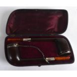 A CASED PAIR OF EARLY 20TH CENTURY AMBER CAPPED PIPES.