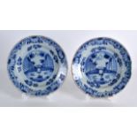 A PAIR OF 18TH CENTURY DELFT BLUE AND WHITE DISHES painted with landscapes. 6.5ins diameter.