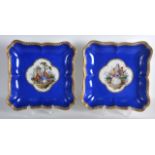 A PAIR OF 18TH CENTURY MEISSEN SQUARE FORM PORCELAIN DISHES painted with central quatrefoil panels