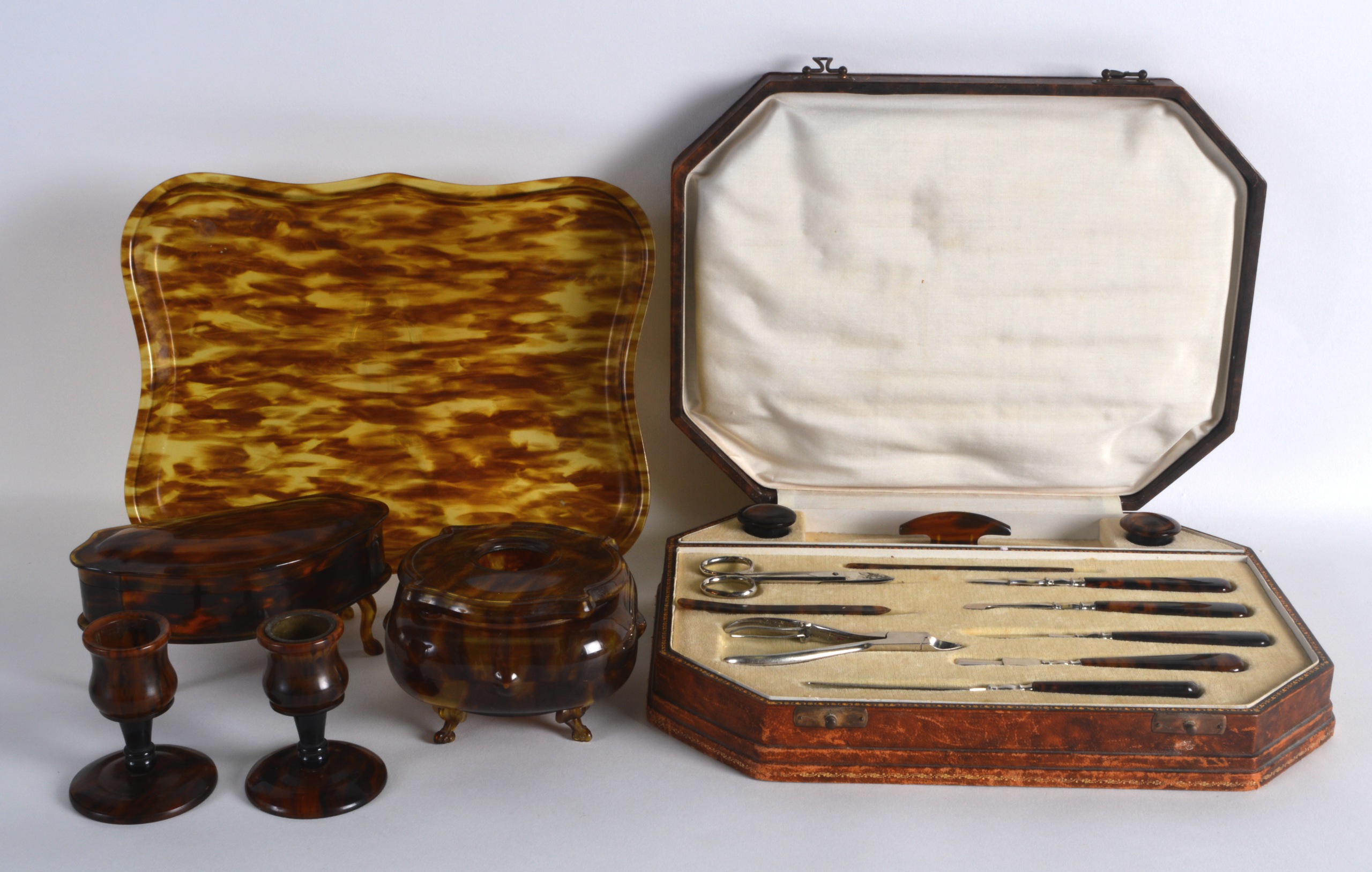 AN ART DECO CASED FAUX TORTOISESHELL DRESSING MANICURE SET together with a matching dressing table