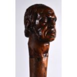 A LATE VICTORIAN CARVED WOOD WALKING CANE the terminal carved as a stern male. 2Ft 10ins long.