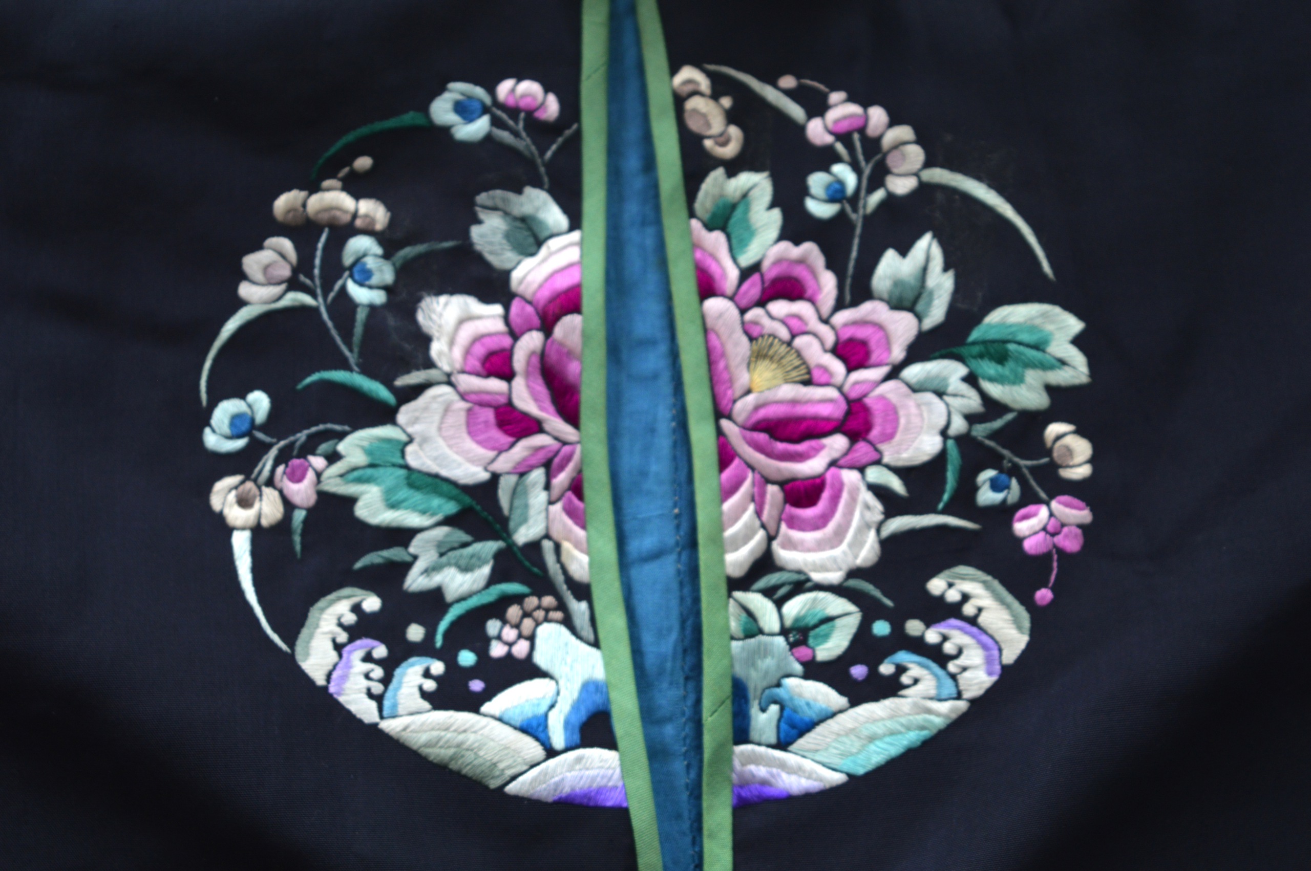 AN EARLY 20TH CENTURY CHINESE BLACK SILKWORK ROBE decorated with panels of flowers, over crashing - Image 2 of 6