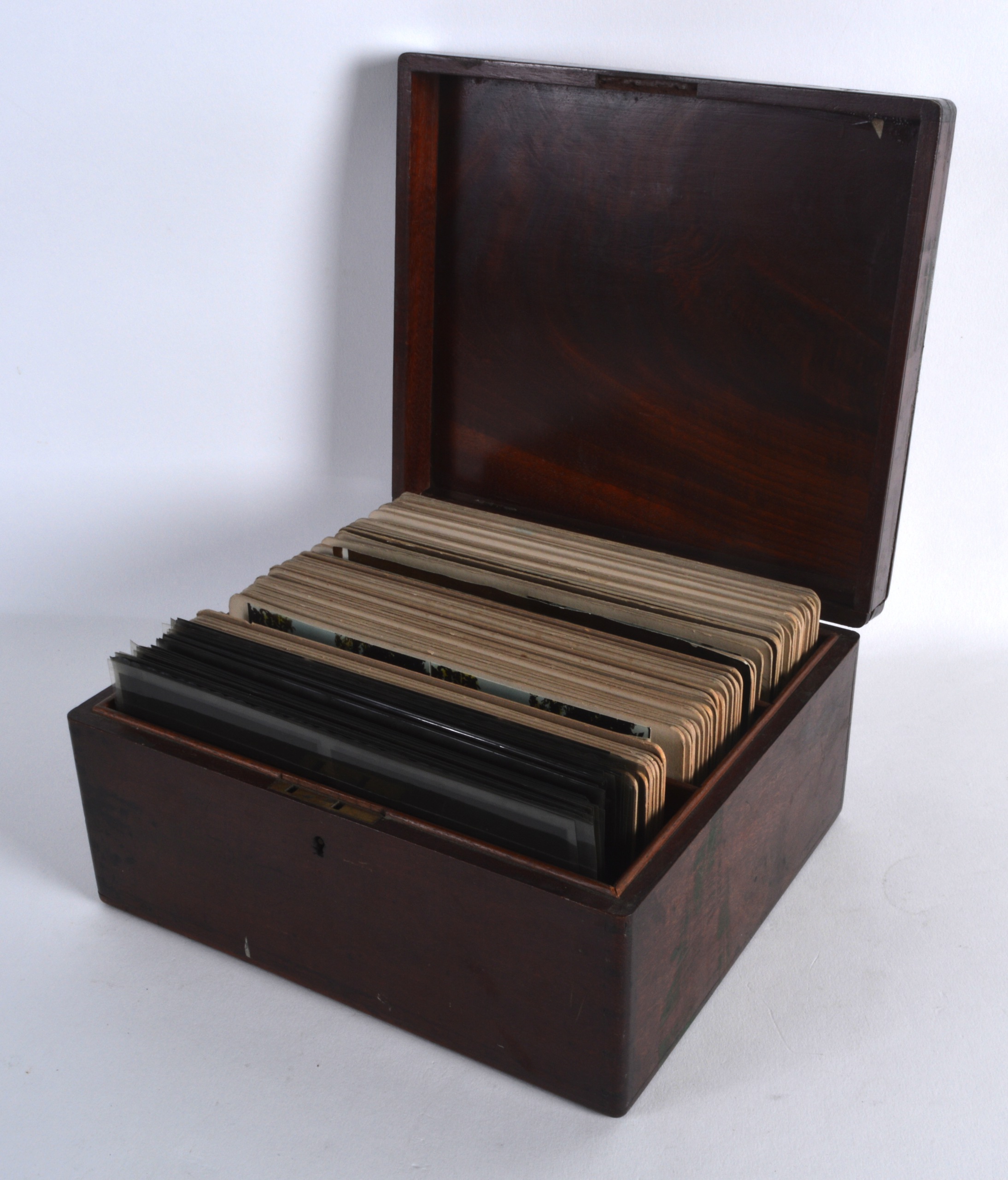 A BOX OF EDWARDIAN PHOTOGRAPHIC AND CARD SLIDES contained within a mahogany box. (qty)