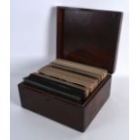 A BOX OF EDWARDIAN PHOTOGRAPHIC AND CARD SLIDES contained within a mahogany box. (qty)