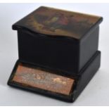 AN EARLY 20TH CENTURY RUSSIAN BLACK LACQUER BOX decorated with a scene of lovers within a landscape.