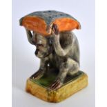 A SMALL PORTUGUESE MAJOLICA TOOTHPICK HOLDER by Jose Cunha, modelled as a monkey holding aloft a