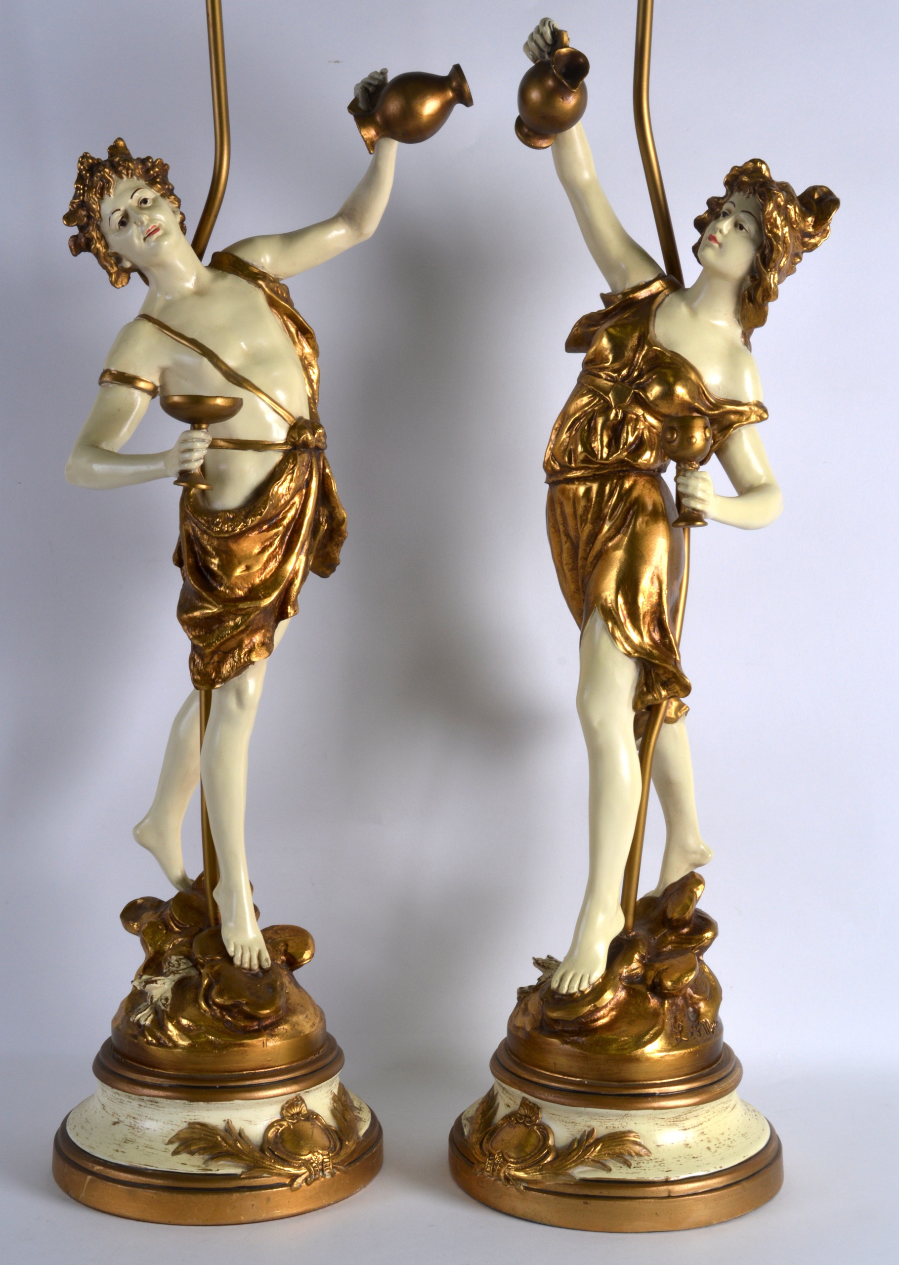 A PAIR OF EARLY 20TH CENTURY PAINTED TERRACOTTA FIGURES converted to lamps, upon painted metal