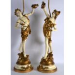 A PAIR OF EARLY 20TH CENTURY PAINTED TERRACOTTA FIGURES converted to lamps, upon painted metal