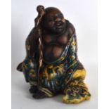 A 19TH CENTURY JAPANESE MEIJI PERIOD POTTERY FIGURE OF A BUDDHA painted with flowers. 7.25ins high.