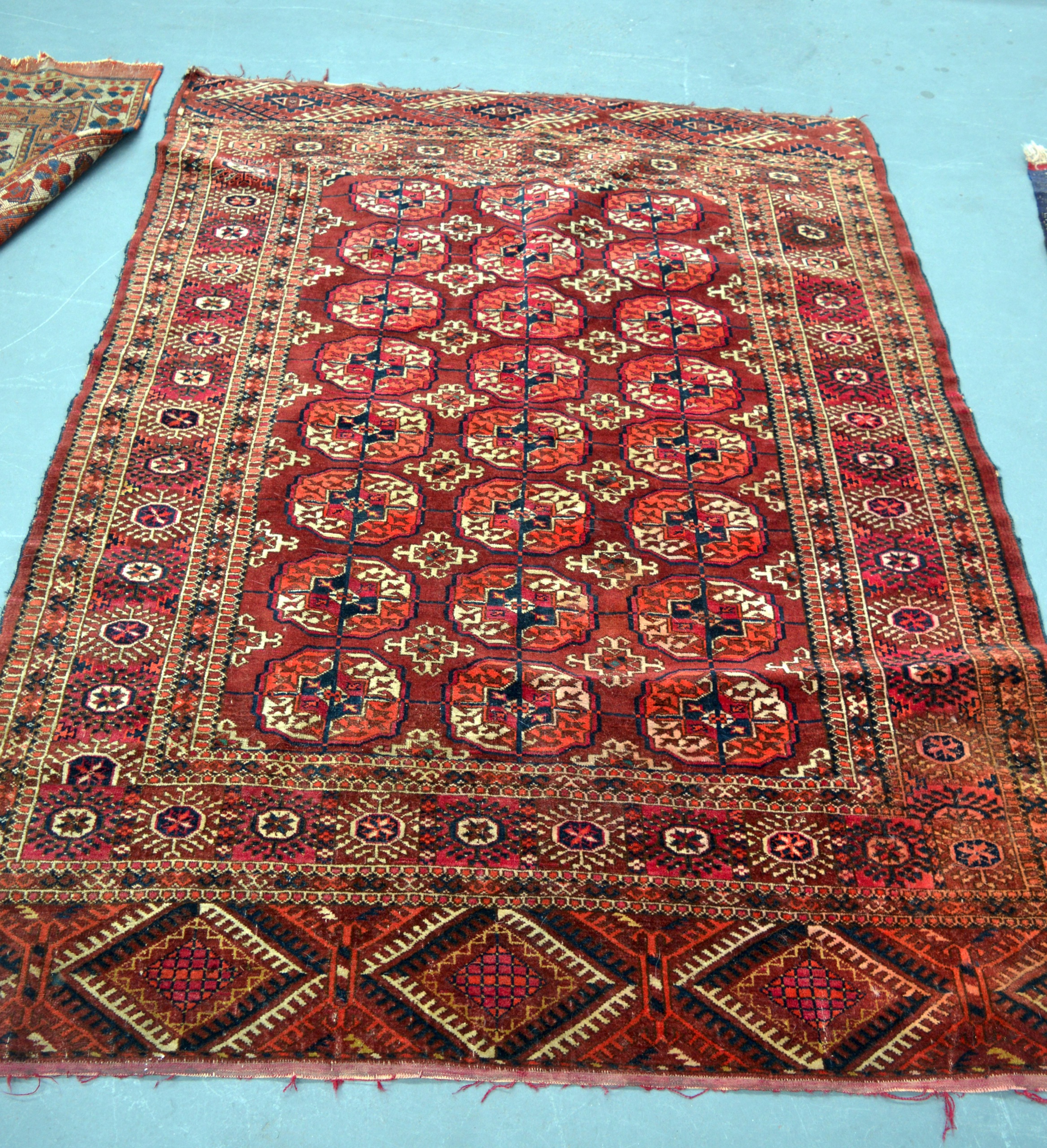 A RED GROUND PERSIAN RUG decorated with medallions within a floral border. 5Ft 10ins x 4ft 4ins.