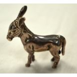AN ENGLISH HALLMARKED SILVER FIGURE OF A DONKEY. 1.75ins wide.