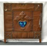 AN UNUSUAL ARTS AND CRAFTS COPPER AND ENAMEL PANEL inset with a Ruskin style large lobed emblem