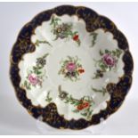 AN 18TH CENTURY WORCESTER CIRCULAR SCALLOPED DISH printed with flowers. 9Ins diameter.