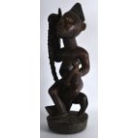 AN EARLY 20TH CENTURY AFRICAN CARVED WOOD FERTILITY FIGURE modelled as a female holding a child. 1Ft