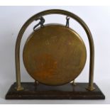 AN UNUSUAL EARLY 20TH CENTURY ENGRAVED BRASS 'PIXIE' TABLE GONG. 11Ins wide.