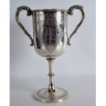 A VICTORIAN TWIN HANDLED SILVER CUP incised with motifs and a vacant cartouche. 15.5oz. London 1874.