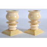 A PAIR OF EARLY 20TH CENTURY CARVED IVORY CANDLESTICKS C1910 with circular stems and square form