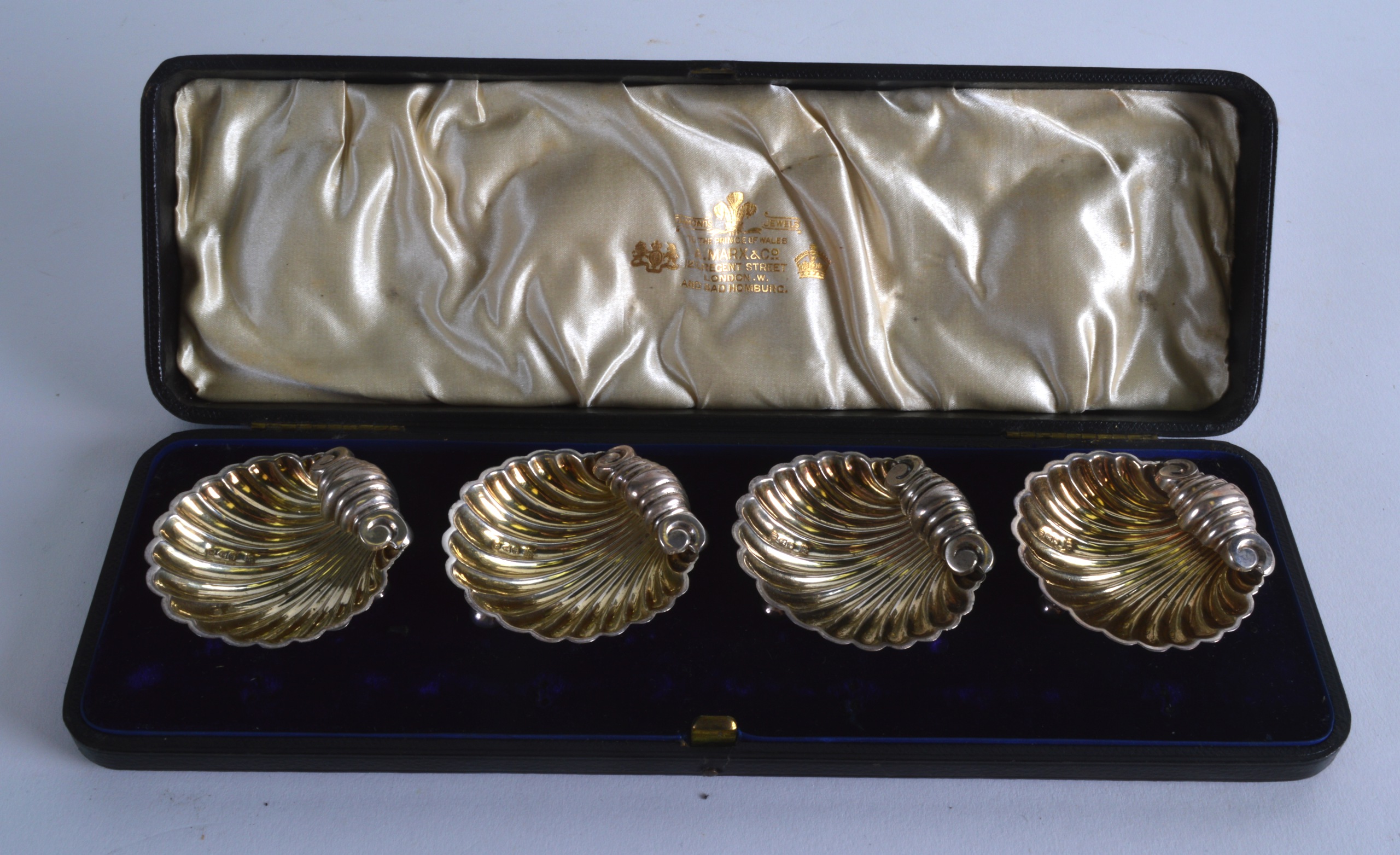 A CASED SET OF VICTORIAN SILVER SALTS in the form of shells. Each 2.25ins wide.