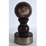 AN INTERESTING SILVER MOUNTED CRICKET BALL upon a turned wood stand. (2)