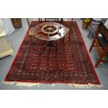 A LARGE EARLY 20TH CENTURY PERSIAN RED GROUP CARPET together with a smaller rug. (2)