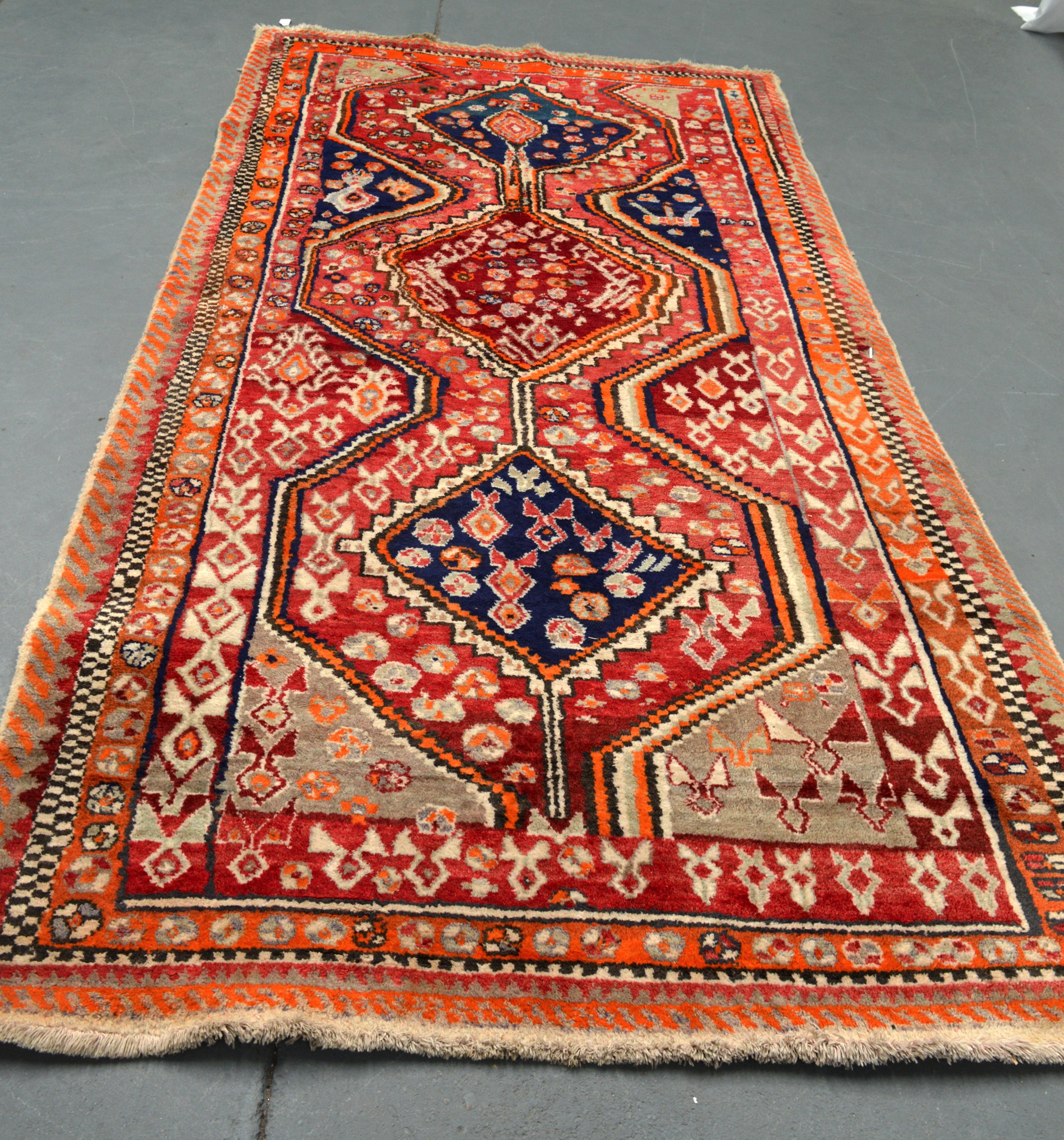 A LARGE AND UNUSUAL ORANGE GROUND CARPET decorated with central blue and red medallions. 9Ft 6ins