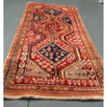 A LARGE AND UNUSUAL ORANGE GROUND CARPET decorated with central blue and red medallions. 9Ft 6ins