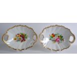 A PAIR OF GERMAN KPM BERLIN TWIN HANDLED DISHES painted with floral studies under a gilt rim. 10.