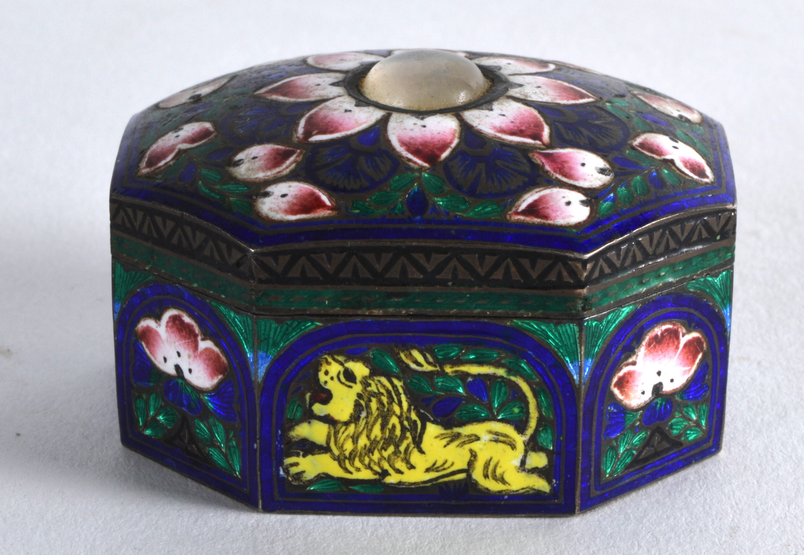 A SMALL EARLY 20TH CENTURY INDIAN SILVER AND ENAMEL PILL BOX decorated with lions and foliage.