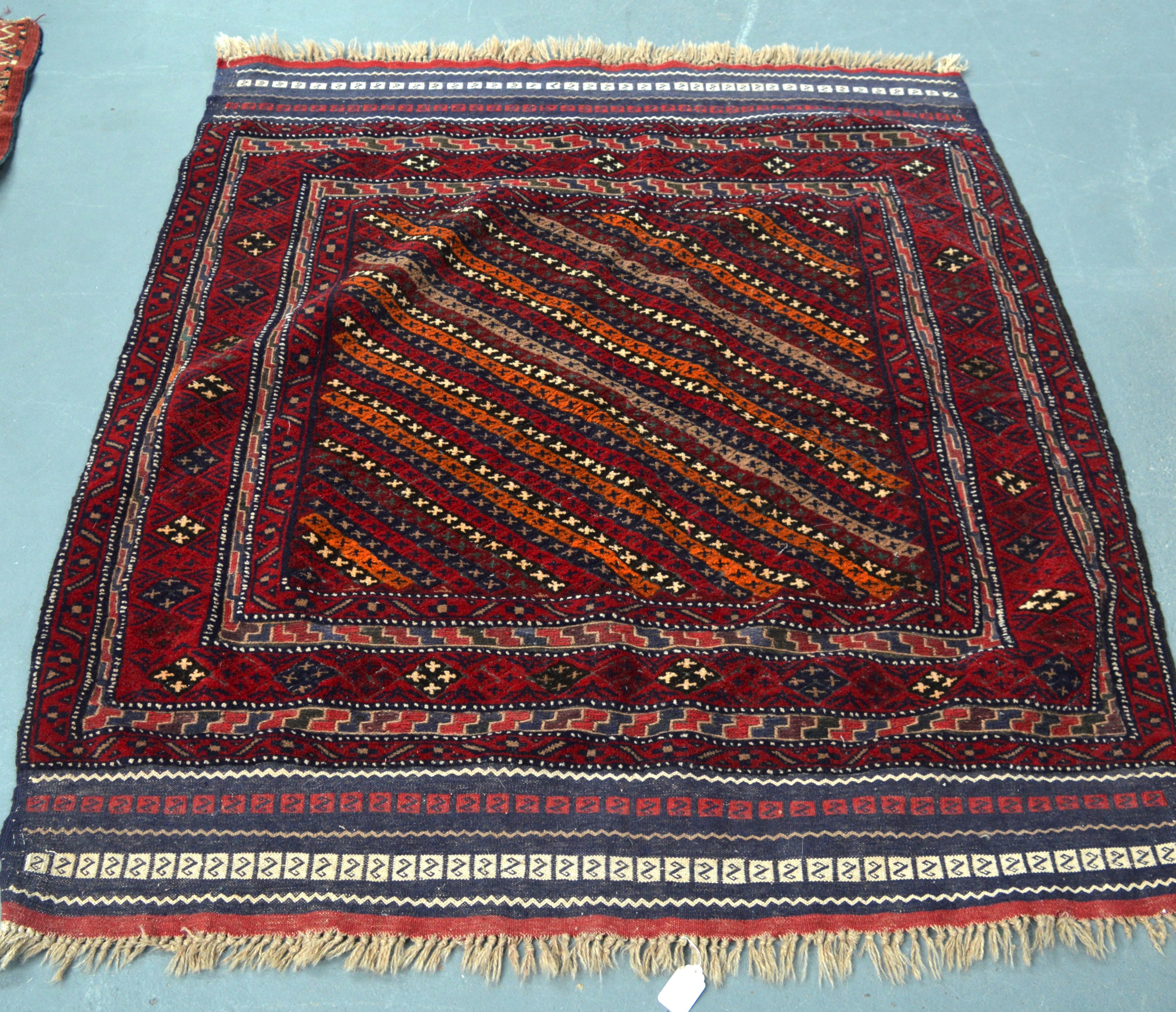 AN UNUSUAL RED GROUND EASTERN RUG decorated with unusual diamond shaped medallions. 4Ft 8ins x 4ft