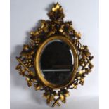 A LATE 19TH/20TH CENTUEY FRENCH GILTWOOD MIRROR with grape and vine mounts. 1Ft 2ins wide.