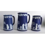 A COMPOSITE GROUP OF WEDGWOOD JASPERWARE GRADUATED JUGS decorated with classical figures under acorn