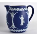 A 19TH CENTURY WEDGWOOD BARREL SHAPED JASPERWARE MILK JUG decorated with classical figures under