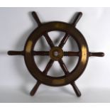 AN EARLY 20TH CENTURY CARVED WOOD BRASS BOUND SHIPS WHEEL. 1Ft 11ins wide.