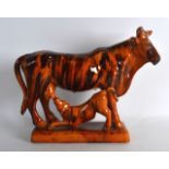 A 19TH CENTURY TREACLE GLAZED POTTERY FIGURE OF AN OX modelled with a calf suckling beneath. 12.5ins