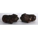 A PAIR OF EARLY 20TH CENTURY CHINESE CARVED WOOD BUDDHISTIC BEASTS modelled recumbant. 4.75ins
