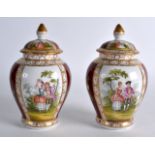 A PAIR OF GERMAN PORCELAIN VASES AND COVERS decorated with scenes in the Dresden style. 5.5ins