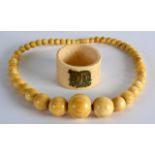 A 19TH CENTURY CARVED IVORY NECKLACE together with a carved bone napkin ring. Ivory 48 grams. (2)