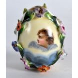 A SMALL RUSSIAN PORCELAIN ENCRUSTED EASTER EGG painted with a central cherub, highlighted in gilt