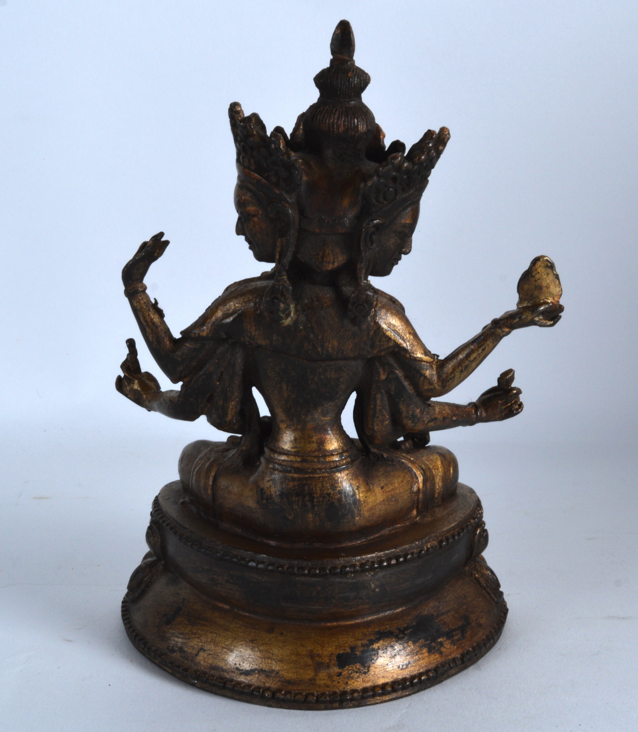 A CHINESE LACQUERED BRONZE FIGURE OF A BUDDHIST GOD modelled upon a triangular base. 7.5ins high. - Image 2 of 3
