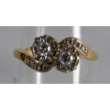 A 9CT YELLOW GOLD AND TWO STONE DIAMOND CROSSOVER RING.