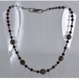 AN EARLY 20TH CENTURY SILVER AND GARNET NECKLACE with Maltese style filigree orbs.